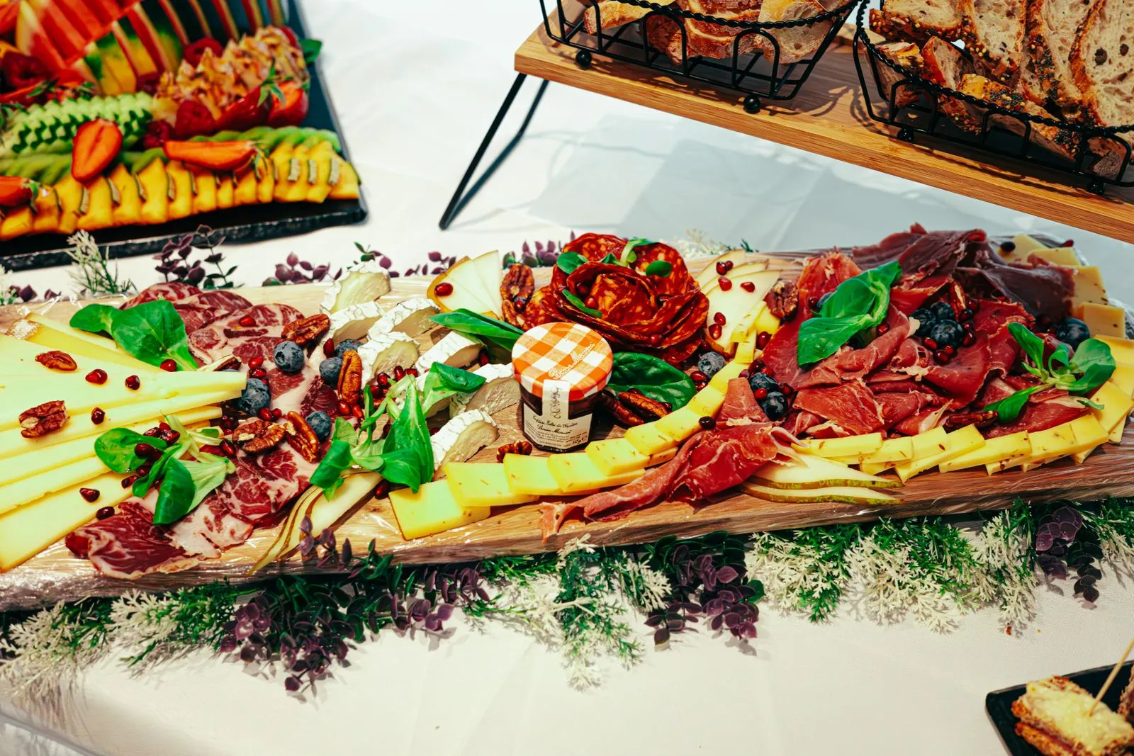 Elegant charcuterie board featuring assorted cheeses, meats, and fresh fruit garnishes.